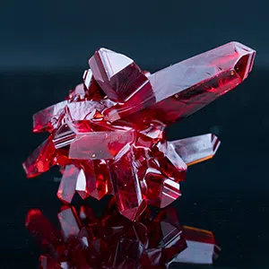 Gros plan sur des cristaux de rubis rouges translucides sur fond sombre