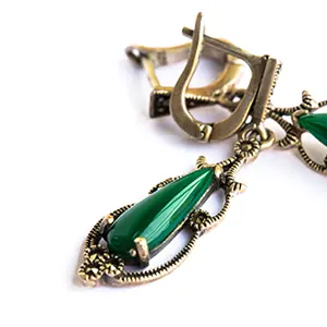 Ecrin présentant des boucles d’oreilles avec une pierre d'émeraude