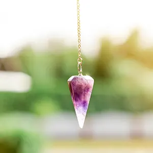 Gros plan sur un bijou (un pendule) de couleur violette réalisé avec un cristal d'améthyste