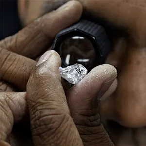 Joaillier observant à la loupe un cristal de diamant