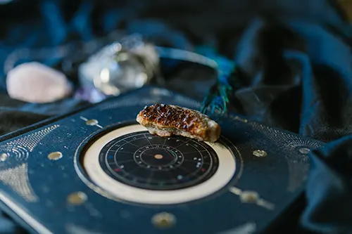 Livre d'astrologie avec une pierre de naissance posée dessus