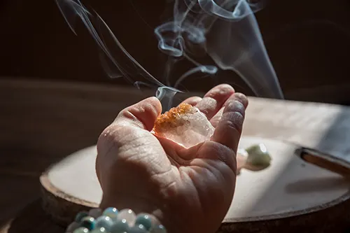 Séance de purification de la pierre tanzanite par fumigation à l'encens
